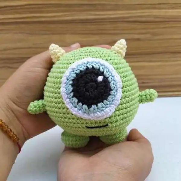 Side view of the Mike Wazowski amigurumi showing one hand extended and symmetrical placement of limbs