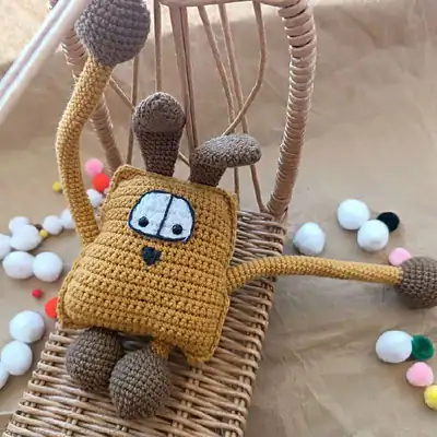 Woof the Dog amigurumi head close-up in golden brown yarn