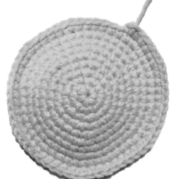 Side view of calico cat amigurumi showing striped tail and sewn-on paw