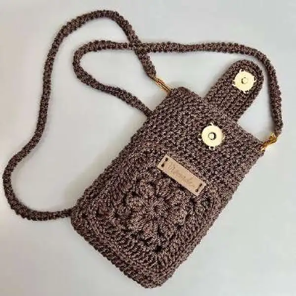 Shoulder strap being threaded through hook bucket on bag