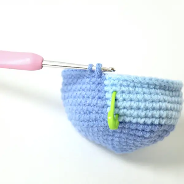Detail of Stitch head with felt eyes and embroidered white dot, showing light blue face patch amigurumi