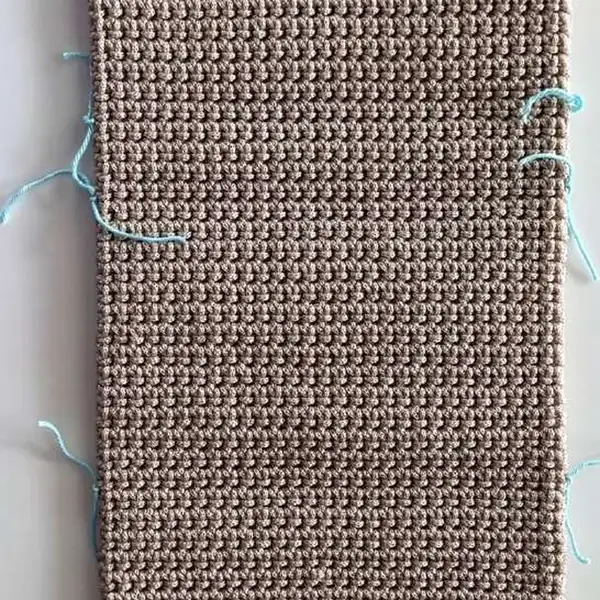 Assembly photo showing main rectangle panel in single crochet worked in back loops and marked fold lines for a crochet bag