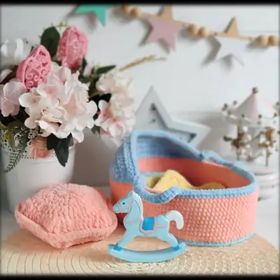 Pastel pink and light blue baby cradle with rainbow pillow and star blanket amigurumi style display