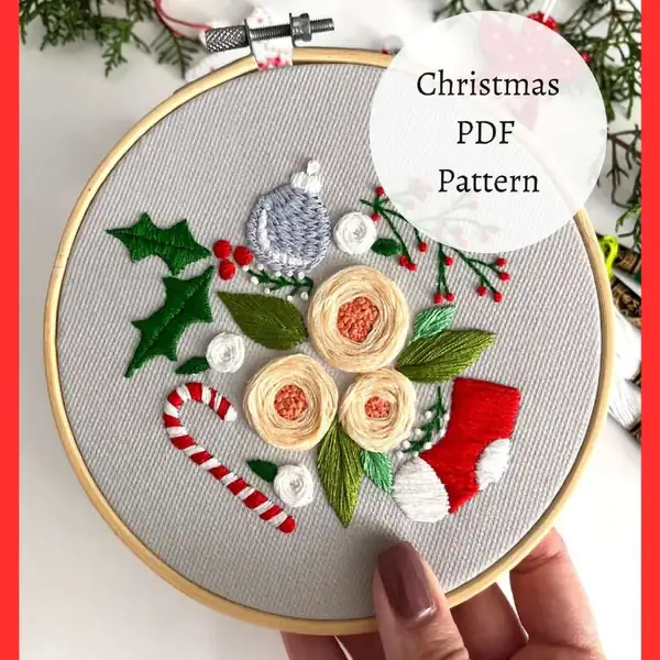 Woven wheel flower and French knot berry details in the finished Christmas hoop