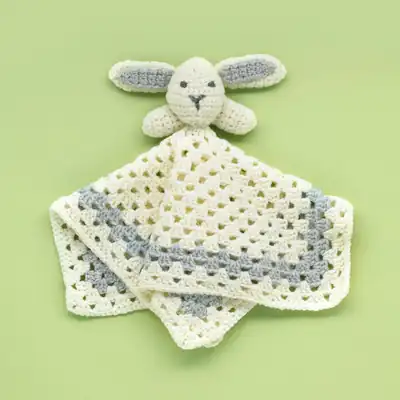 Cover image of Snuggle Bunny amigurumi with blanket on green background