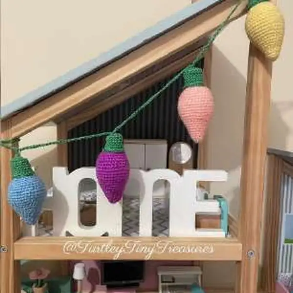 Five finished plush lightbulb amigurumi laid out together showing different colour bulbs and caps