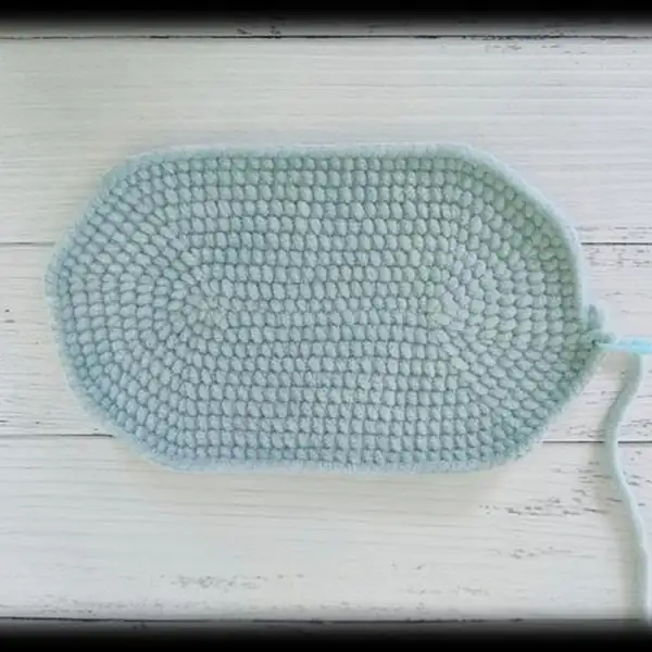 Close-up image of the rainbow pillow and curved pillow shape in chenille yarn for the crochet cradle amigurumi set