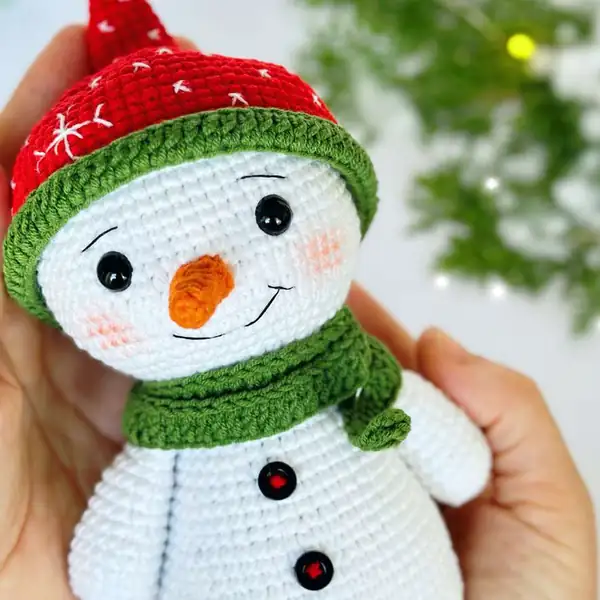 Progress photo showing the crocheted white body and head shape for the snowman amigurumi in mid-stuffing
