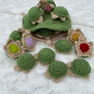 Pair of baby turtle amigurumi pieces in two colors showing the FLO round detail and small circular baby bottoms