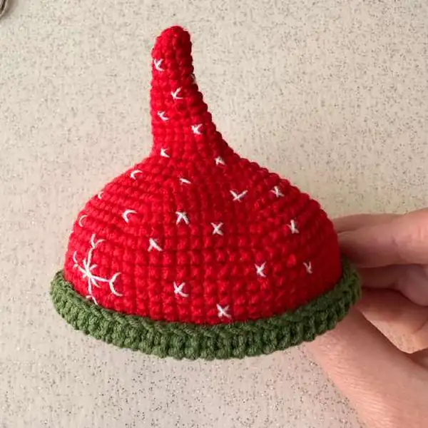 Series of small circular photos showing scarf construction and embroidered face steps for the snowman amigurumi