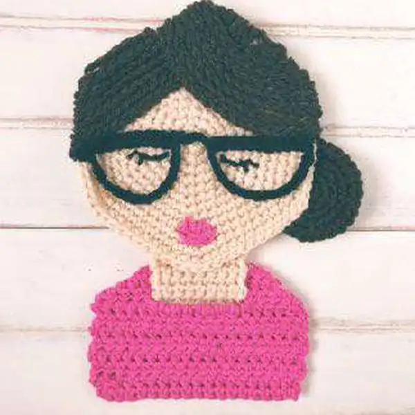 Finished crochet girl portrait wearing sunglasses on display