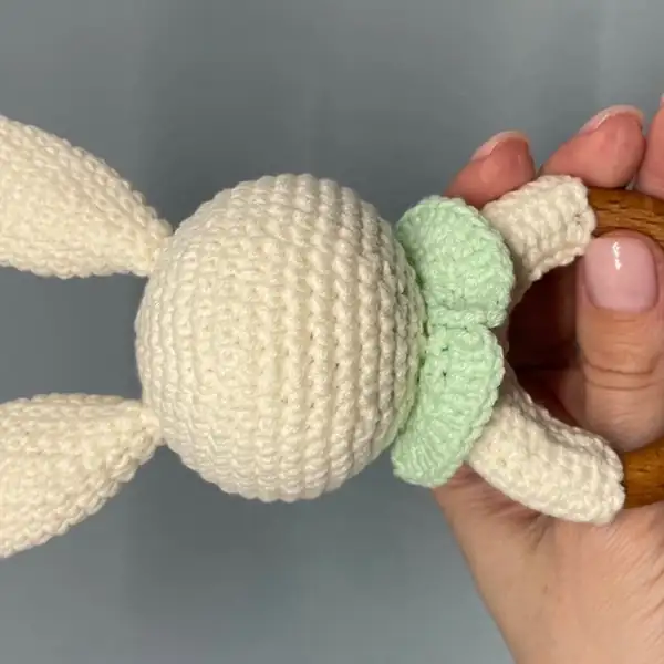 Step-by-step assembly photos showing the wrapped wooden ring and attached head of the bunny amigurumi from the back and front