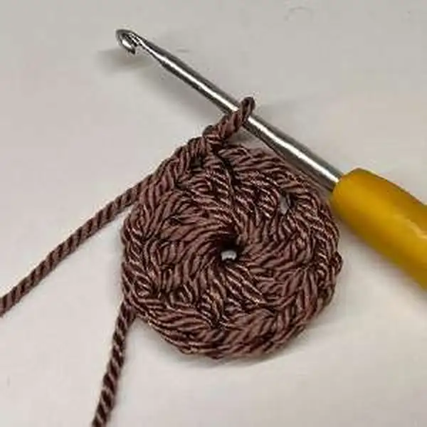 Magnetic button closure on strap with bag in background