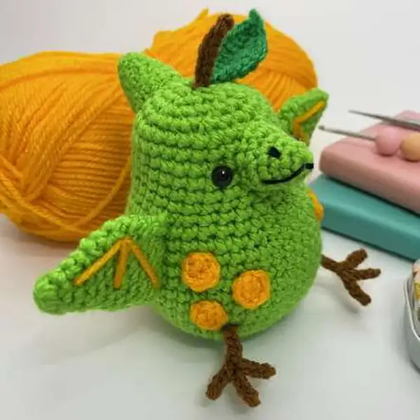 Pearodactyl standing with yarn and crochet tools