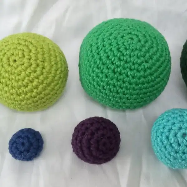 Medium-sized turquoise crochet ball showing smooth curvature.