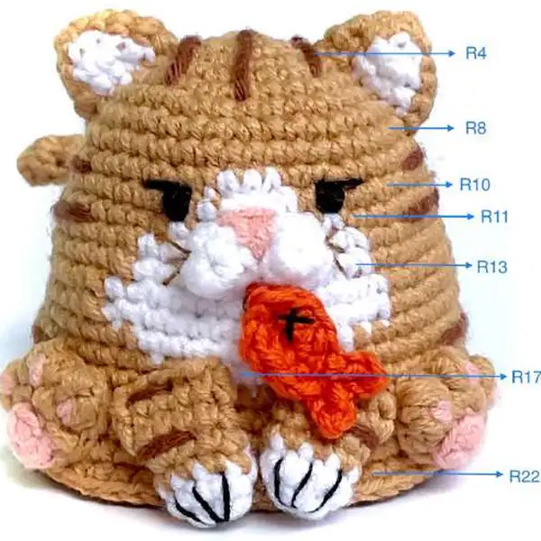 Close-up of the cat muzzle and embroidered nose on the calico amigurumi