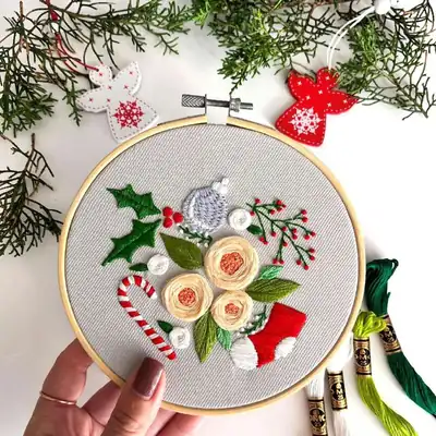 Finished Christmas hoop showing satin-stitched roses and fishbone leaves in a 15 cm hoop