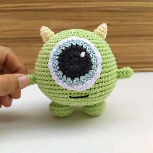 Close-up of layered eye detail on the Mike Wazowski crochet amigurumi showing black pupil and blue rim