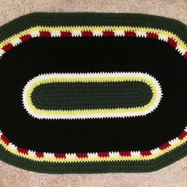 Close-up of chain foundation and first rows showing long oval shaping for crochet race track mat