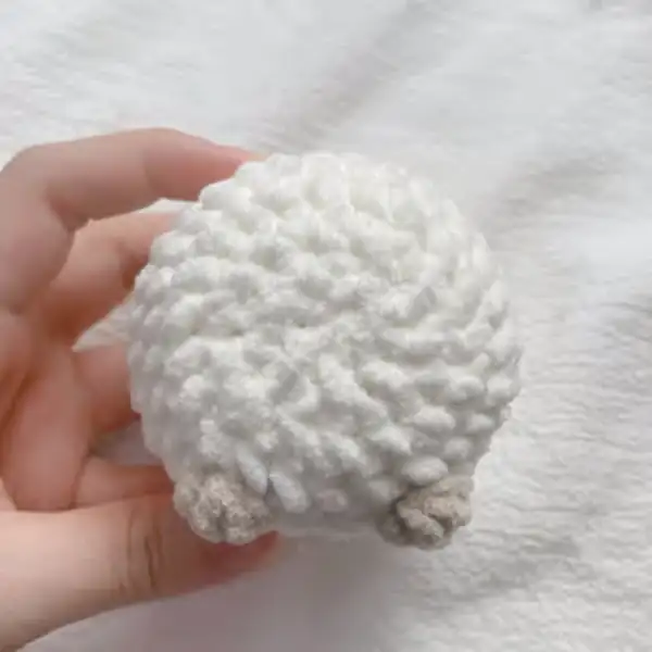 Finished Little Sheep amigurumi sitting on fabric