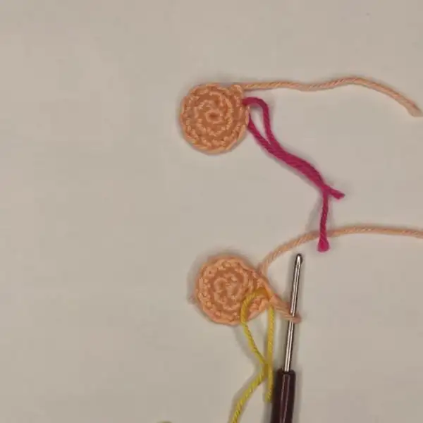 two finished heart keychain amigurumi pieces in peach and white displayed together to show size comparison